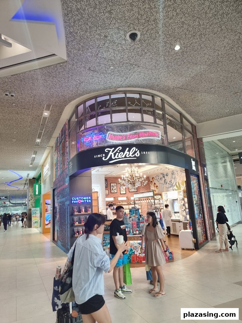 The Kiehl's Plaza Singapura shop front with customers and staff visible inside.