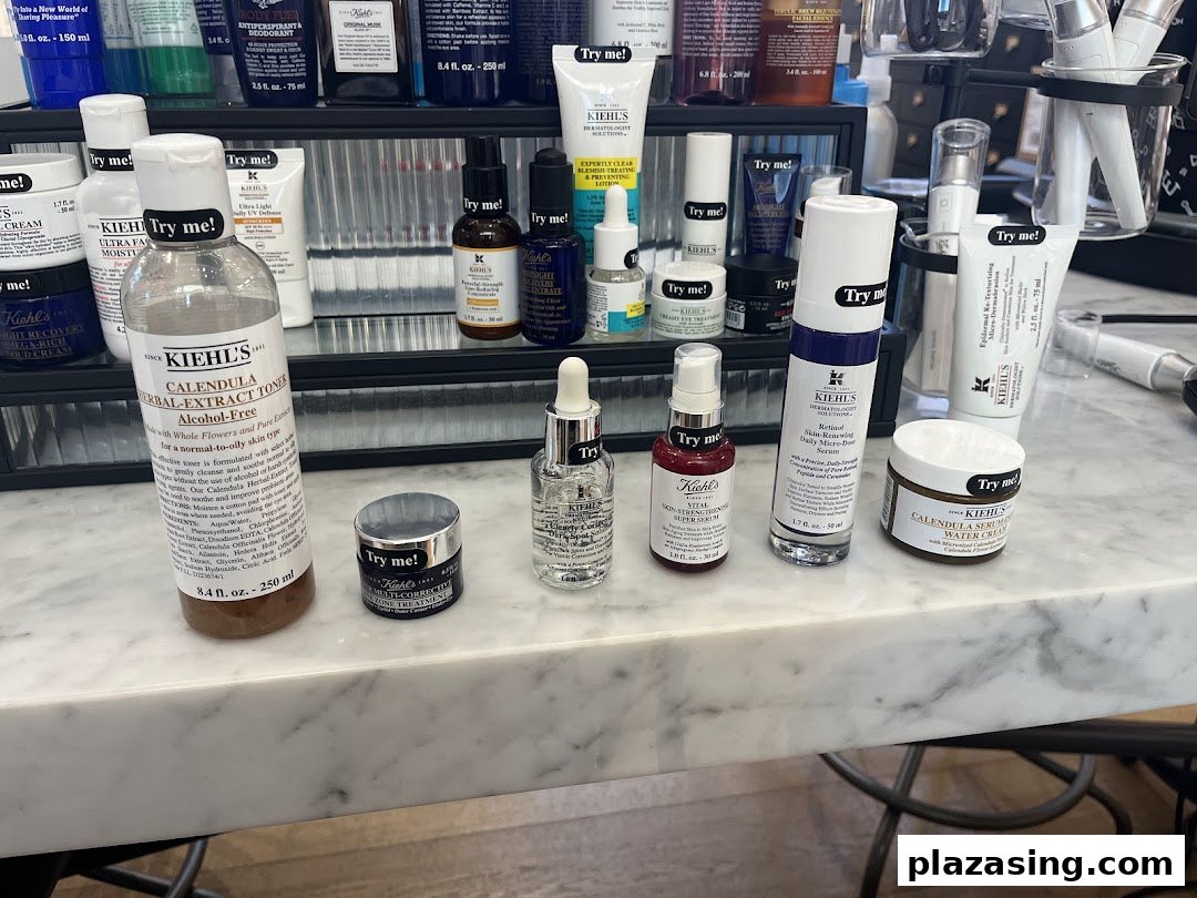 A counter display of various Kiehl's skincare products, many with 'Try me!' labels for sampling.