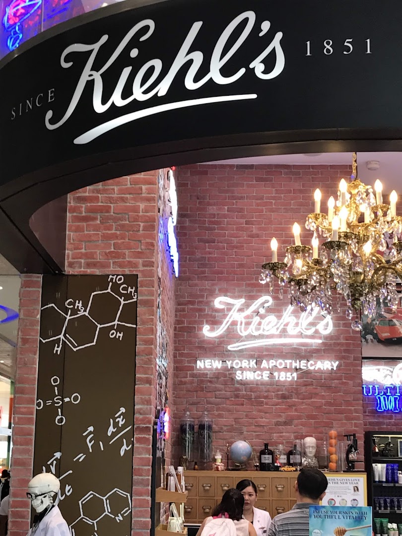 Kiehl's store interior featuring brick walls, a chandelier, and a customer service counter.
