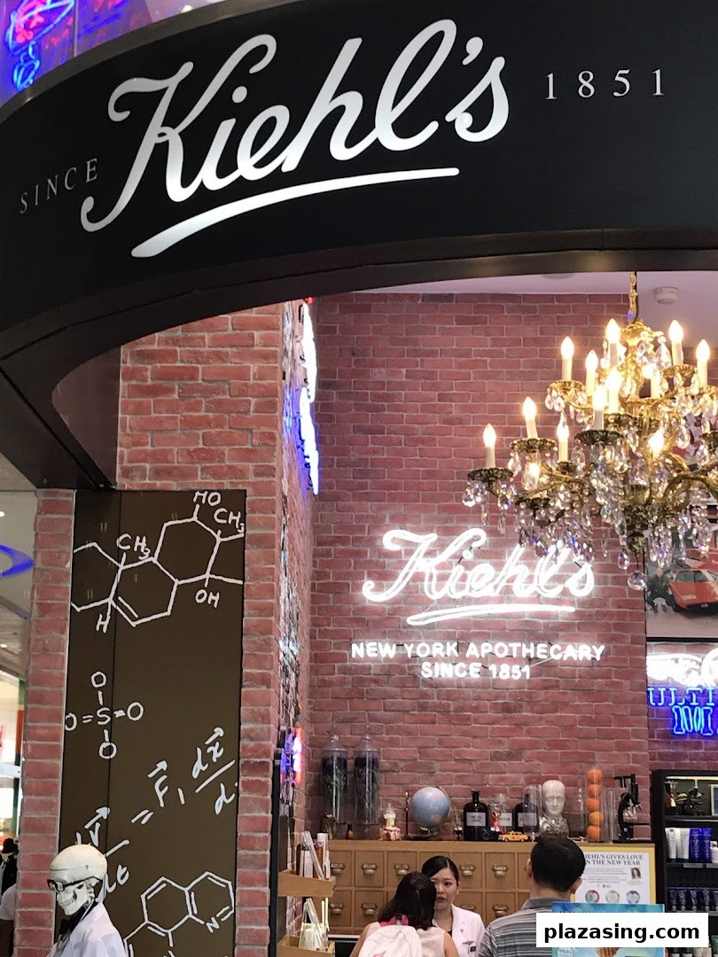 Kiehl's store interior featuring brick walls, a chandelier, and a customer service counter.