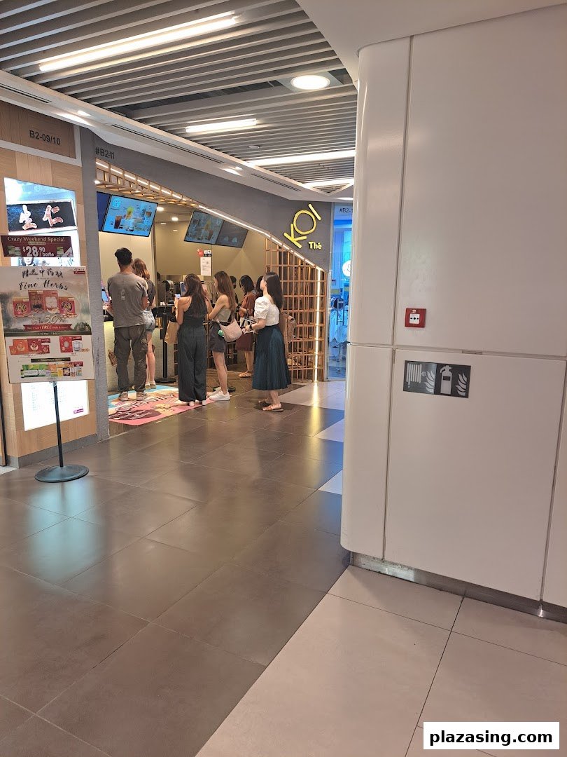 Customers queueing at the bustling entrance of KOI Thé bubble tea shop.