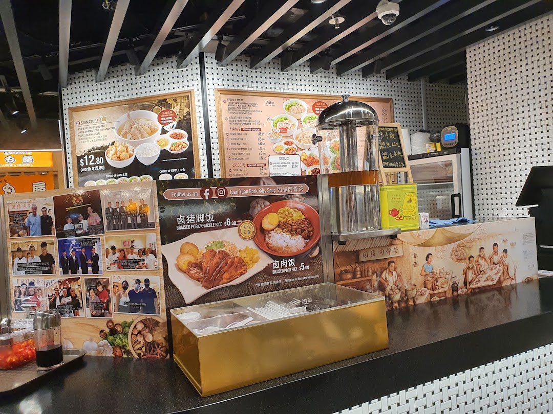 A food stall counter at Kopitiam Food Hall featuring large menu boards and promotional displays.