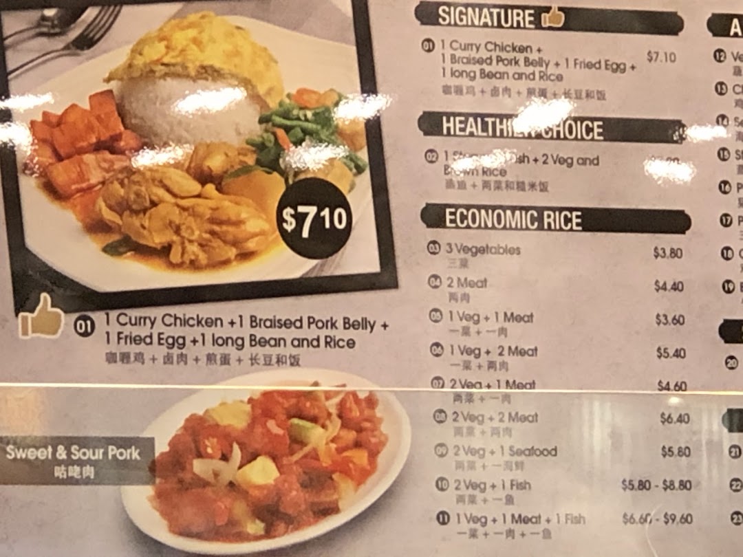 A vibrant menu board displaying various Asian dishes and their prices, including a signature curry chicken set.