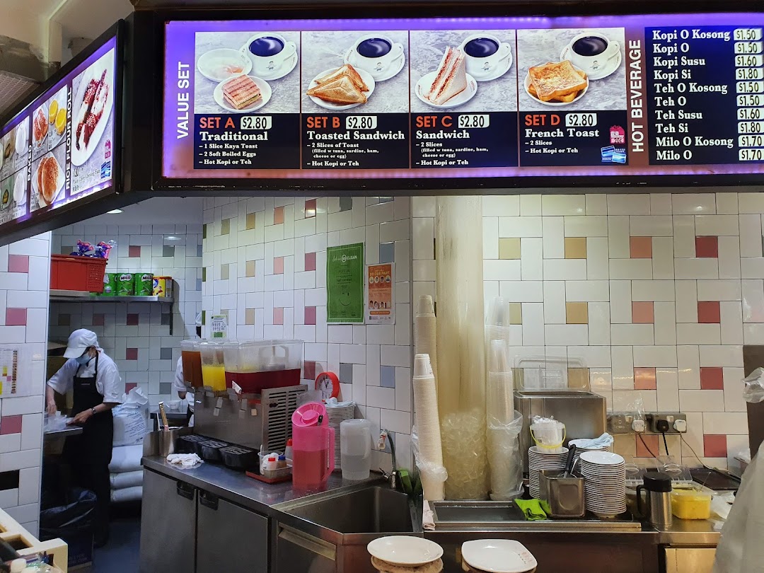 A bright menu board displaying breakfast value sets and hot beverages at Kopitiam Food Hall.