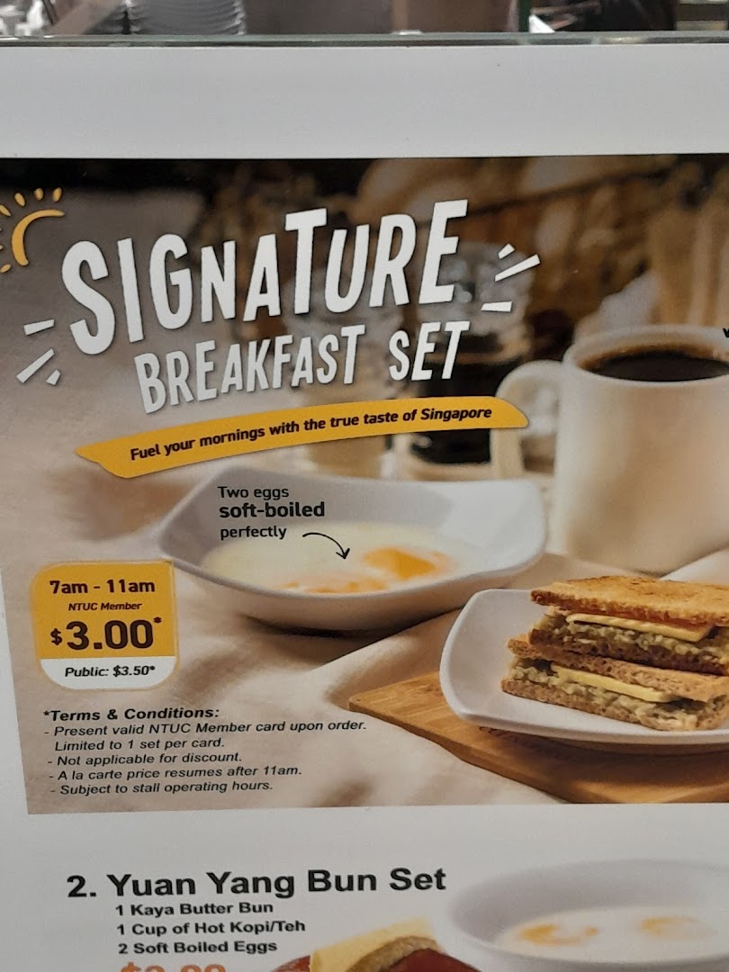 A menu board displaying breakfast sets, including soft-boiled eggs, toast, and coffee, with pricing details.