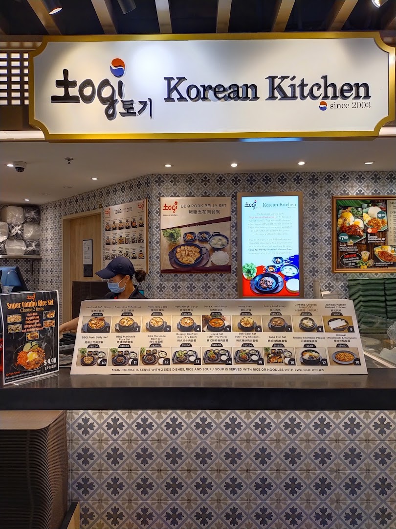 A counter view of Togi Korean Kitchen showcasing various Korean dishes and menu options.