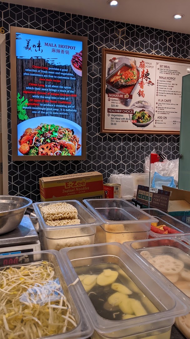 A vibrant Mala Hotpot counter showcasing fresh ingredients and detailed menu boards.