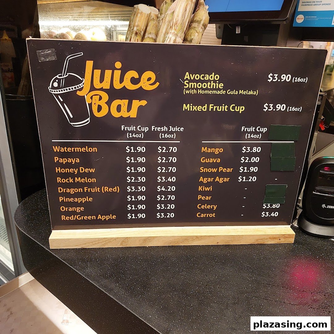 A menu board displaying various fresh juices and fruit cups with prices at Kopitiam Food Hall.