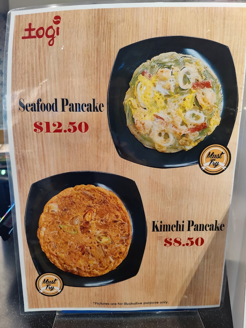 A menu board displaying Seafood Pancake and Kimchi Pancake with prices from togi.