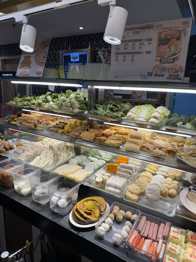 A vibrant display of fresh ingredients and prepared items at a Yong Tau Foo stall, with menu visible.