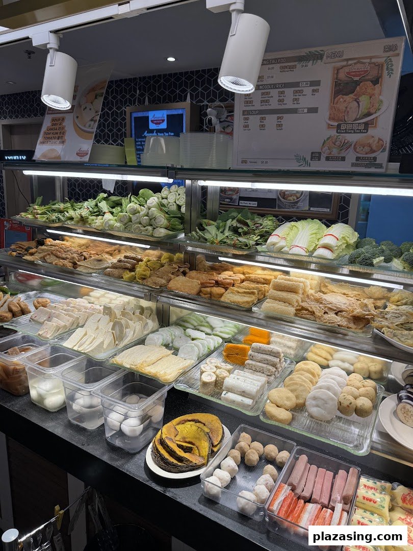 A vibrant display of fresh ingredients and prepared items at a Yong Tau Foo stall, with menu visible.