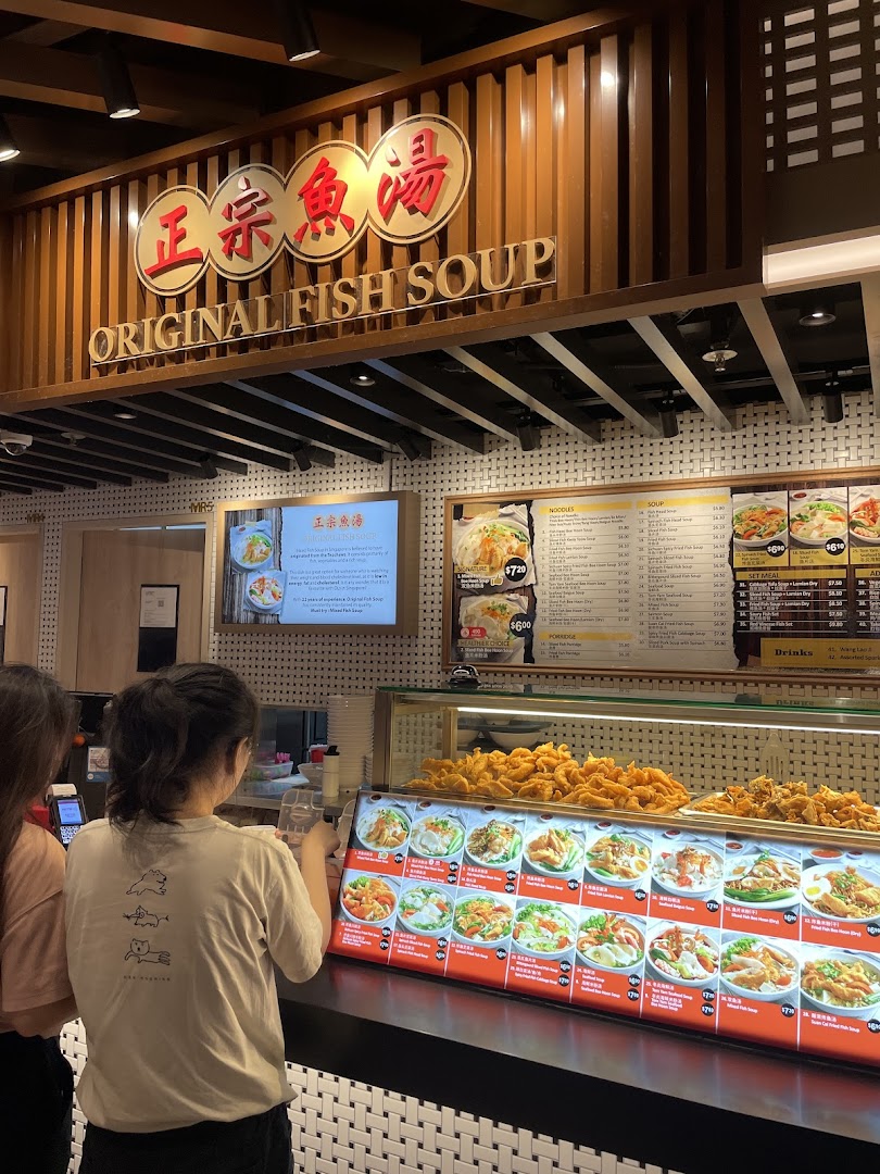 Customers at Original Fish Soup stall in Kopitiam Food Hall, featuring menu boards and food displays.