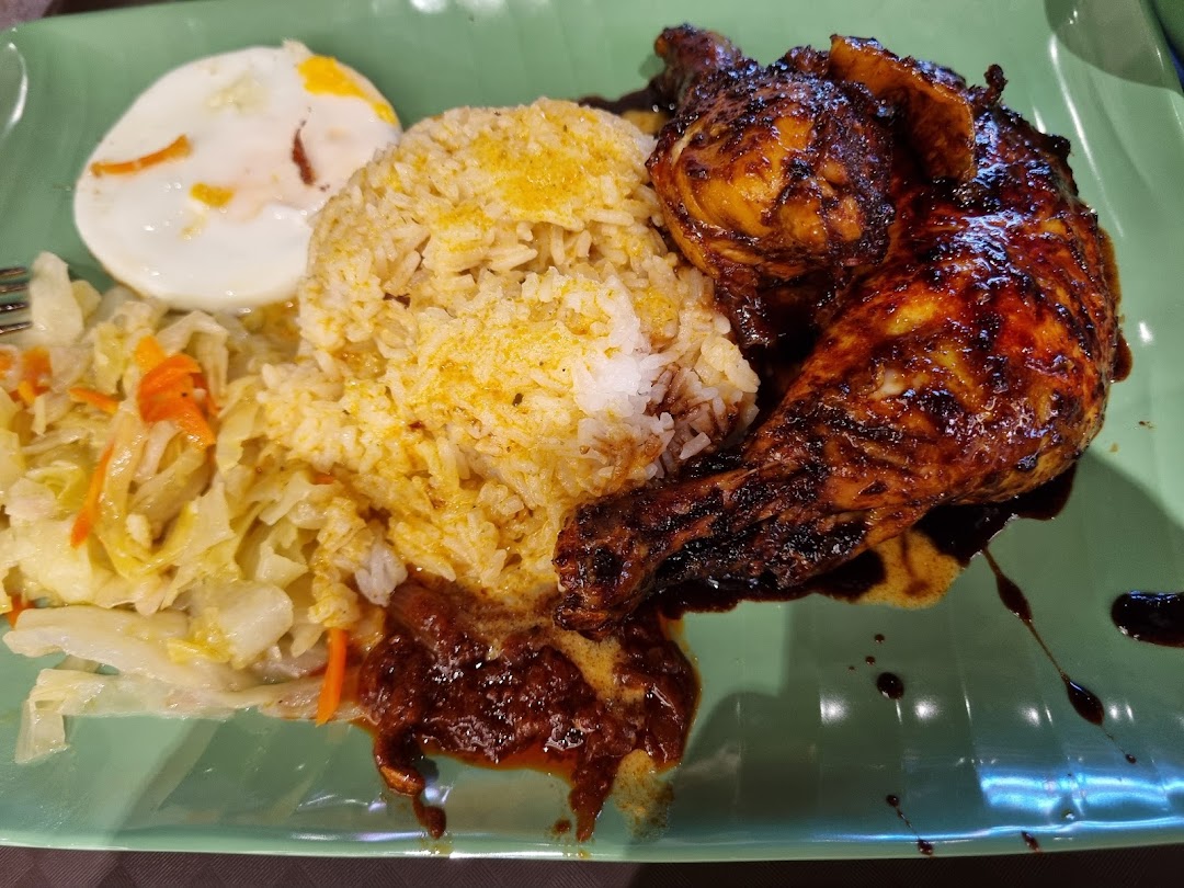 A delicious plate featuring roasted chicken, seasoned rice, stir-fried cabbage, and a fried egg.