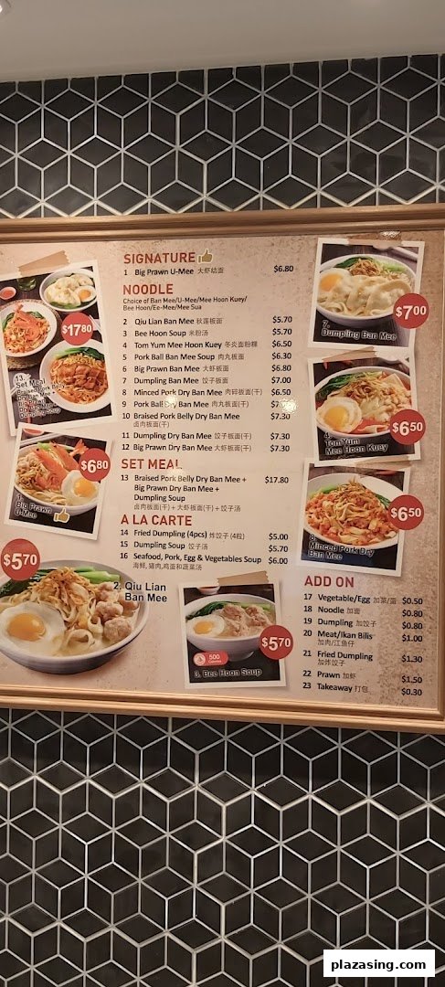A detailed menu board displaying various noodle dishes, set meals, and add-ons with prices.