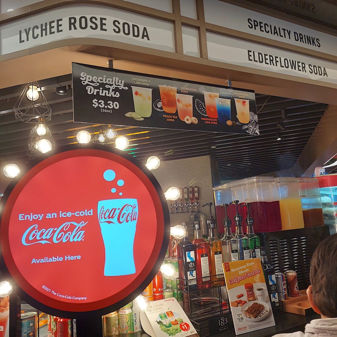 A drinks counter at Kopitiam Food Hall showcasing specialty sodas and Coca-Cola offerings.