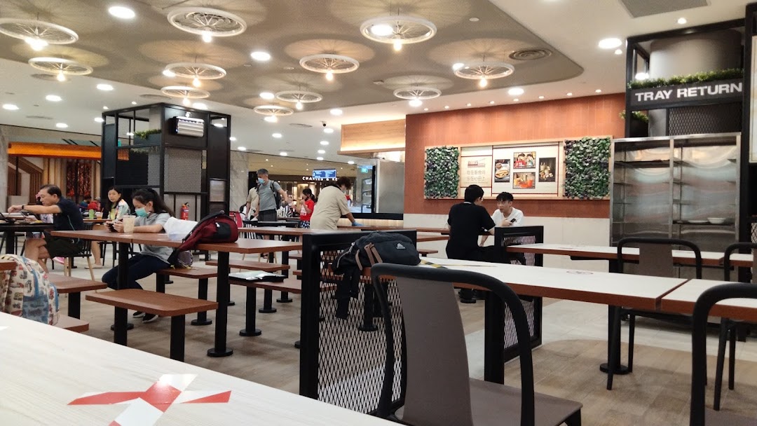 An interior view of Kopitiam Food Hall, showing diners, tables, and a 'Tray Return' station.