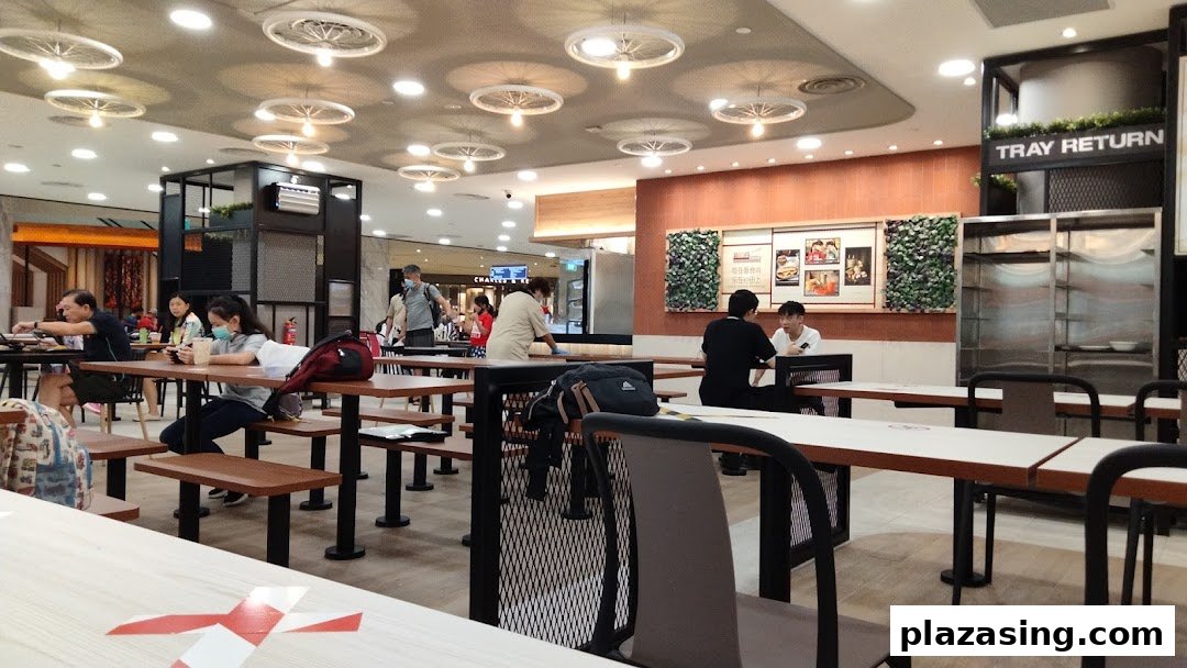 An interior view of Kopitiam Food Hall, showing diners, tables, and a 'Tray Return' station.