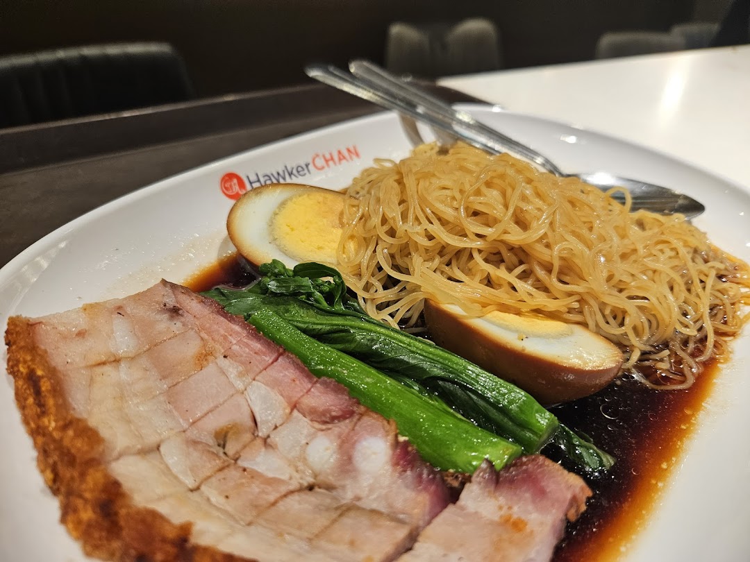 A plate of delicious roasted pork, noodles, boiled egg, and greens from Hawker Chan.