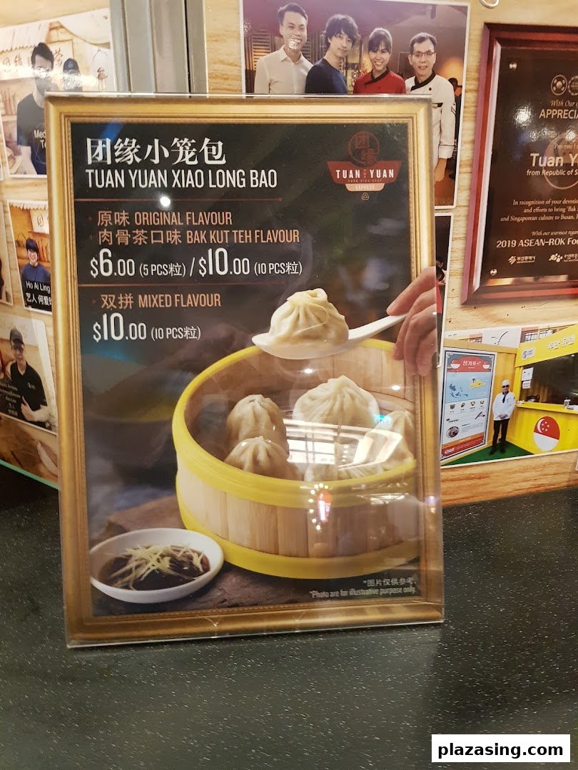 A framed menu display for Tuan Yuan Xiao Long Bao, showcasing various dumpling flavors and prices.