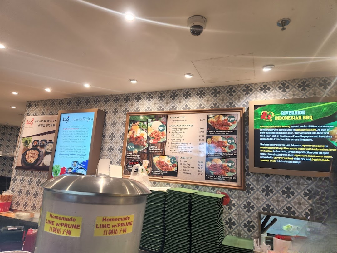 An interior shot of Kopitiam Food Hall showcasing diverse food stalls and menu displays.