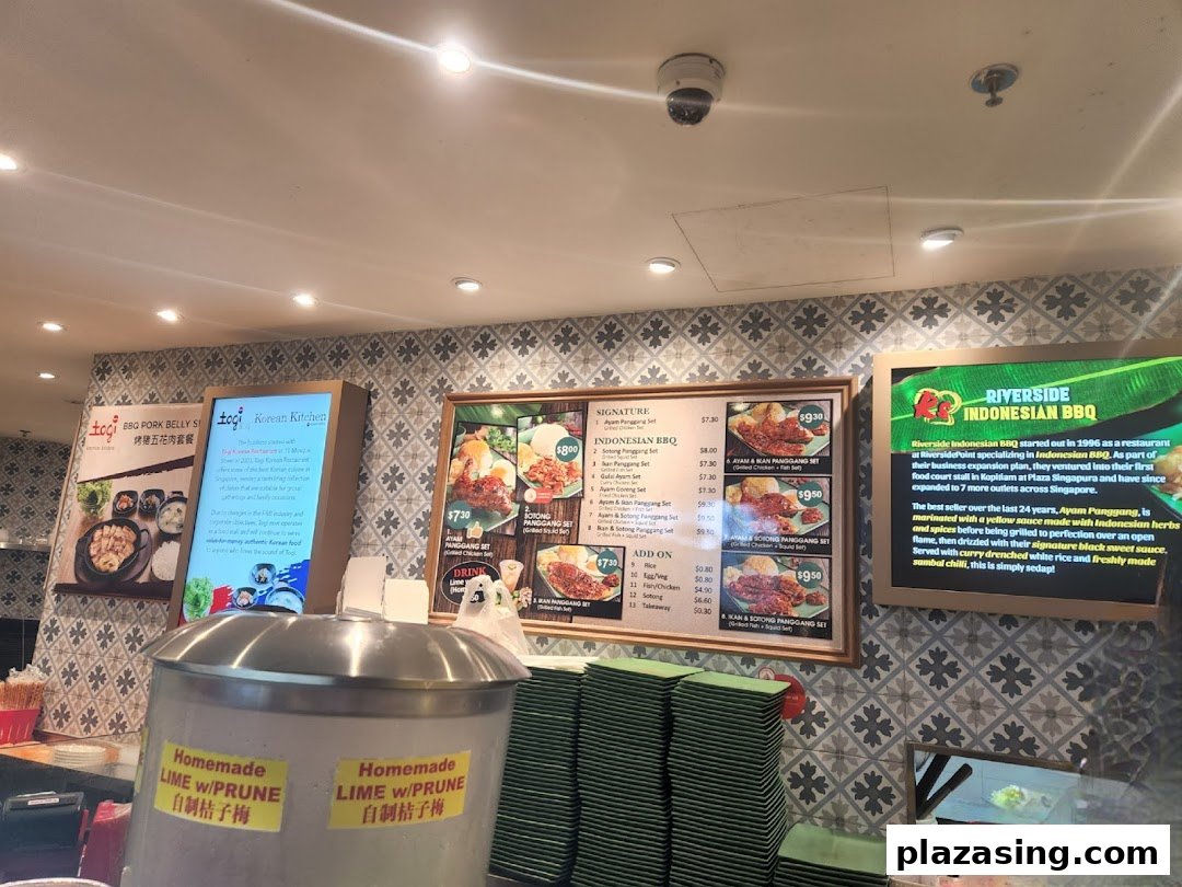 An interior shot of Kopitiam Food Hall showcasing diverse food stalls and menu displays.