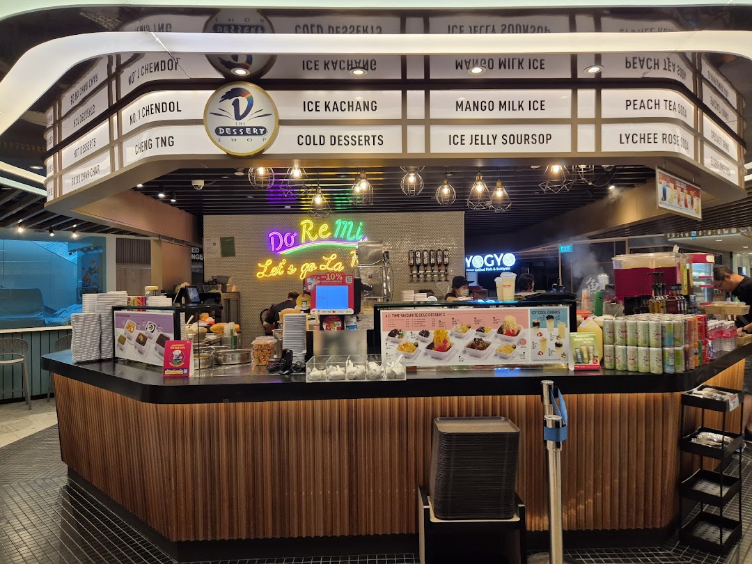A vibrant dessert stall named 'The Dessert Shop' offering a variety of cold treats and beverages.