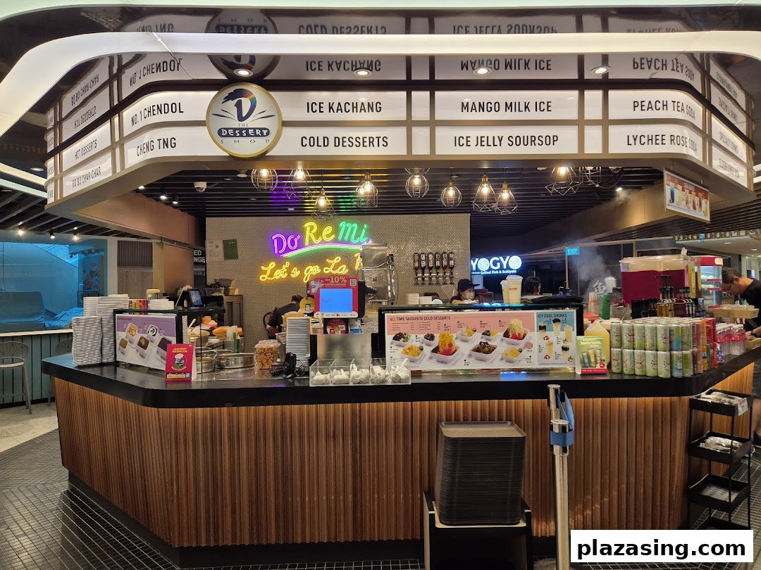 A vibrant dessert stall named 'The Dessert Shop' offering a variety of cold treats and beverages.