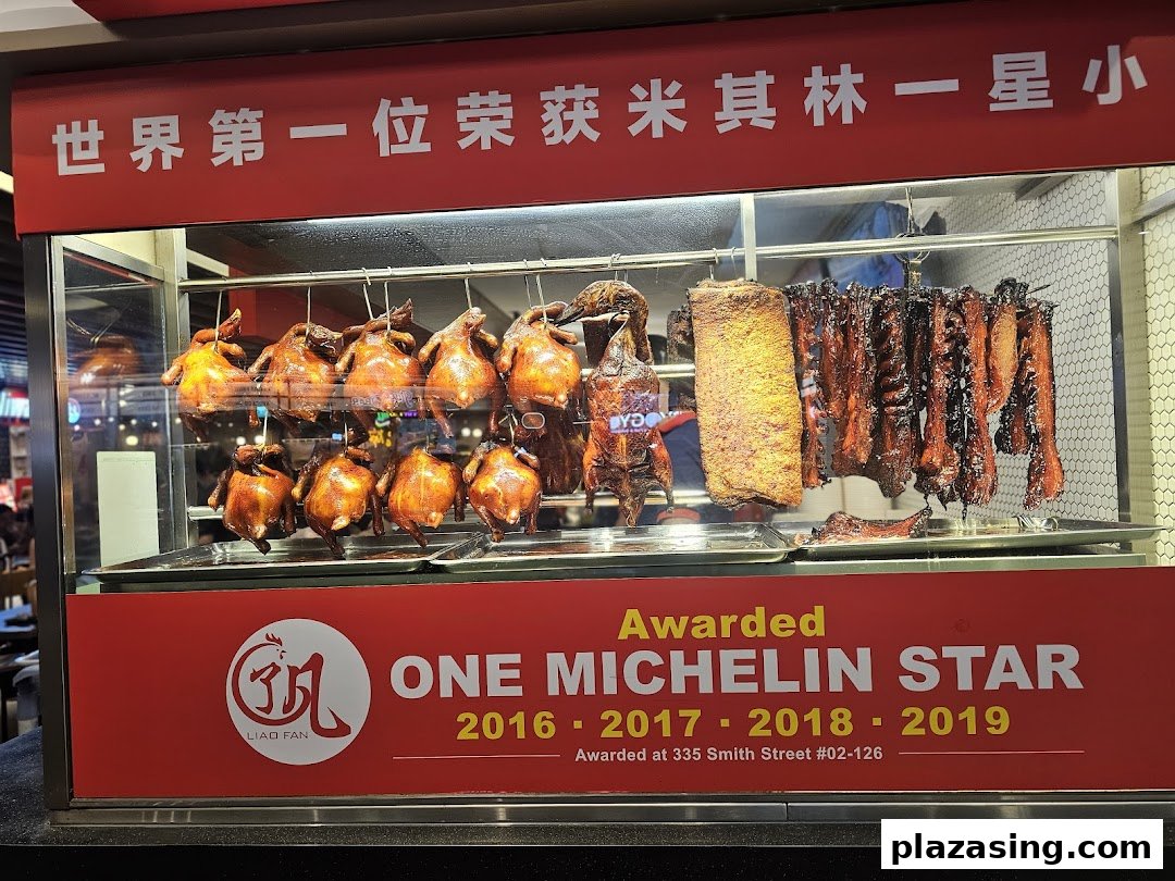A display case showcasing roasted chickens, ducks, and char siew, with a sign highlighting Michelin star awards.