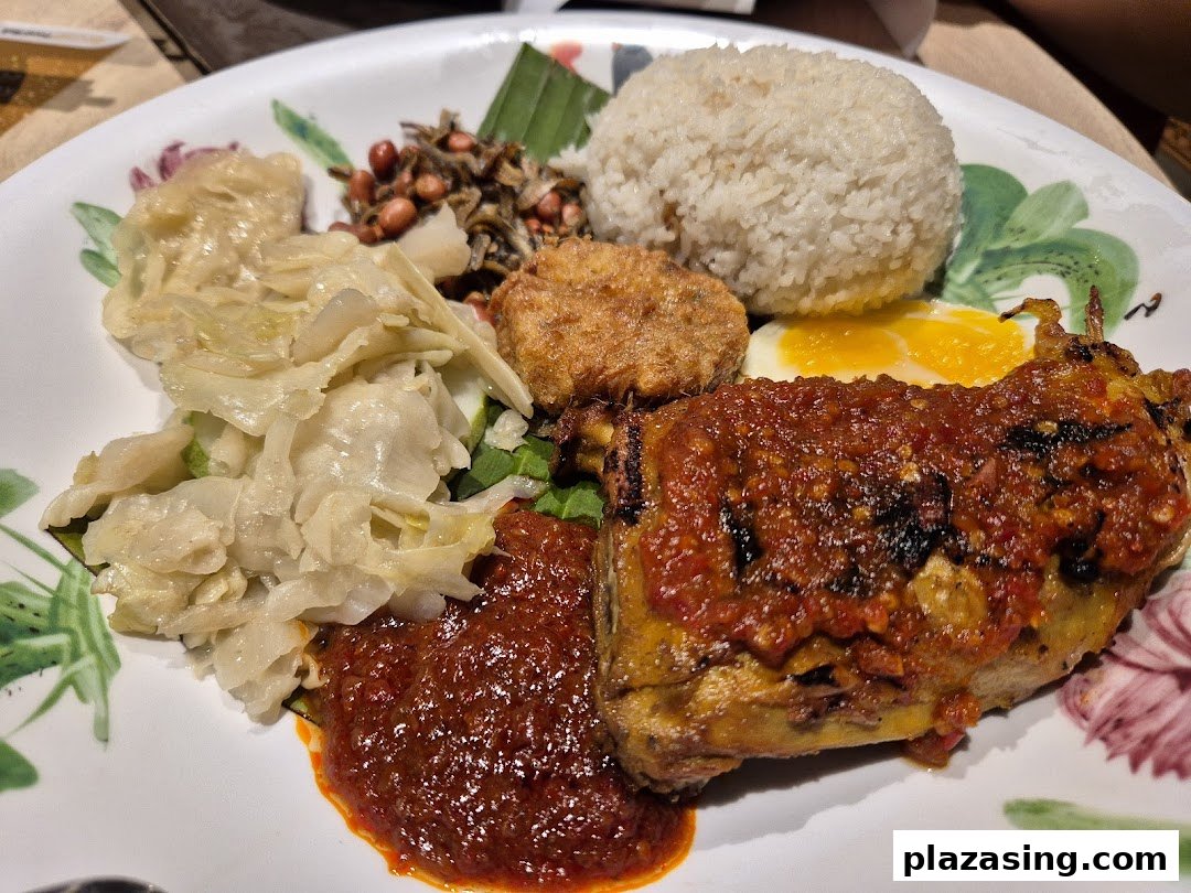 A vibrant plate of Nasi Lemak featuring spicy fried chicken, fluffy rice, egg, and traditional accompaniments.