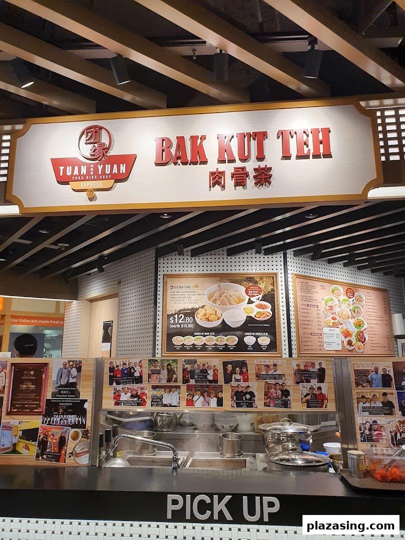 A food stall named Tuan Yuan Bak Kut Teh with a pick-up counter and menu boards.