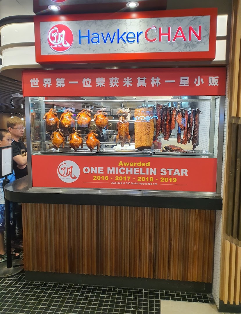 Hawker Chan stall showcasing roasted chickens, ducks, and char siew, highlighting its Michelin star award.