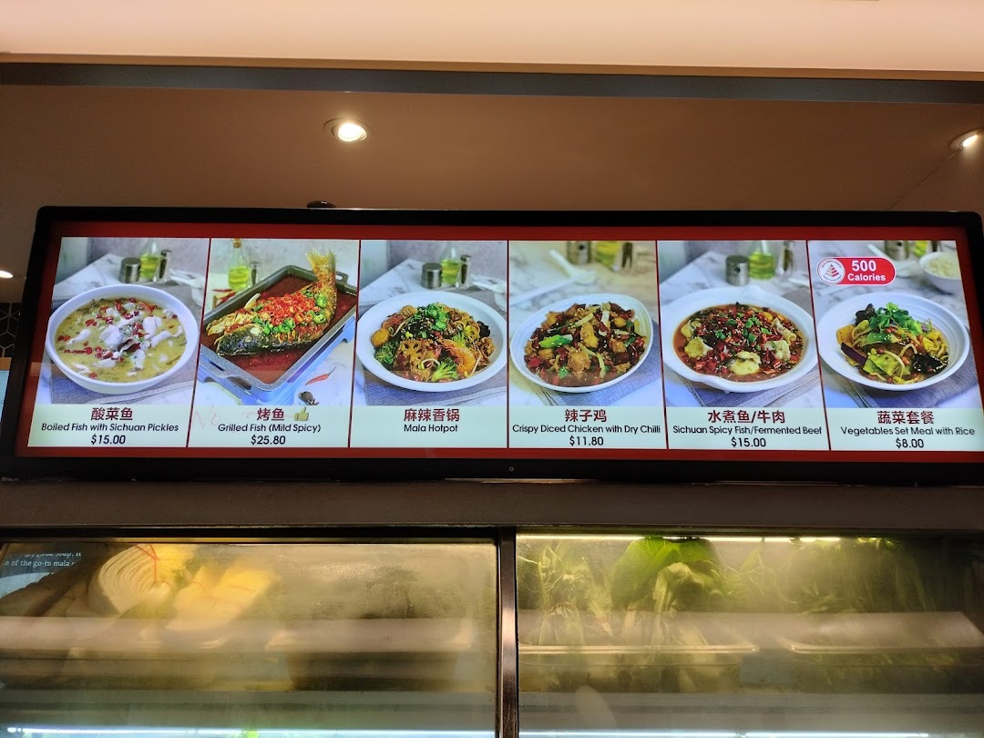 A digital menu board at Kopitiam Food Hall displaying various Sichuan and Chinese dishes with prices.