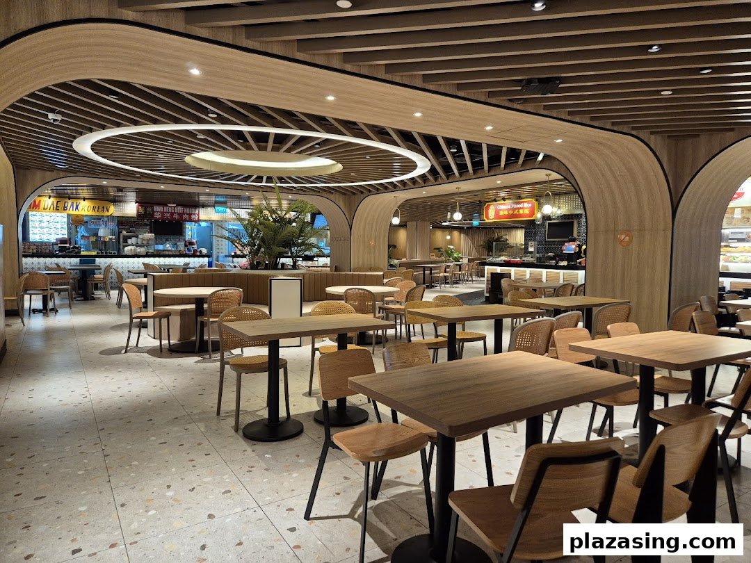 A spacious and modern food hall interior with numerous dining tables and various food stalls.