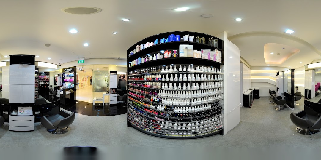 A modern beauty salon interior featuring extensive nail polish displays, salon chairs, and beauty product sections.