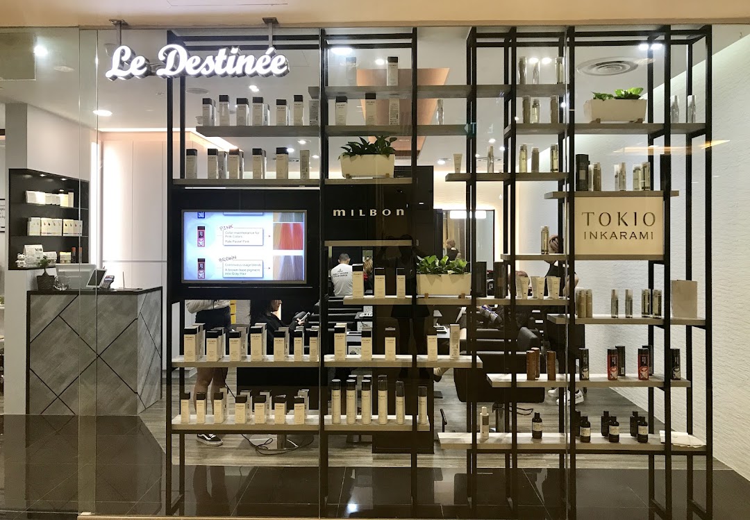 The shop front of Le Destinee, a hair salon, showcasing products and its modern interior.