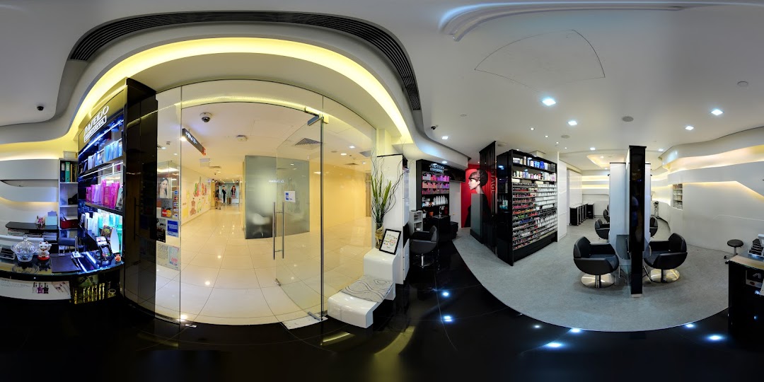 Panoramic view of a modern hair and beauty salon interior with product displays and styling stations.