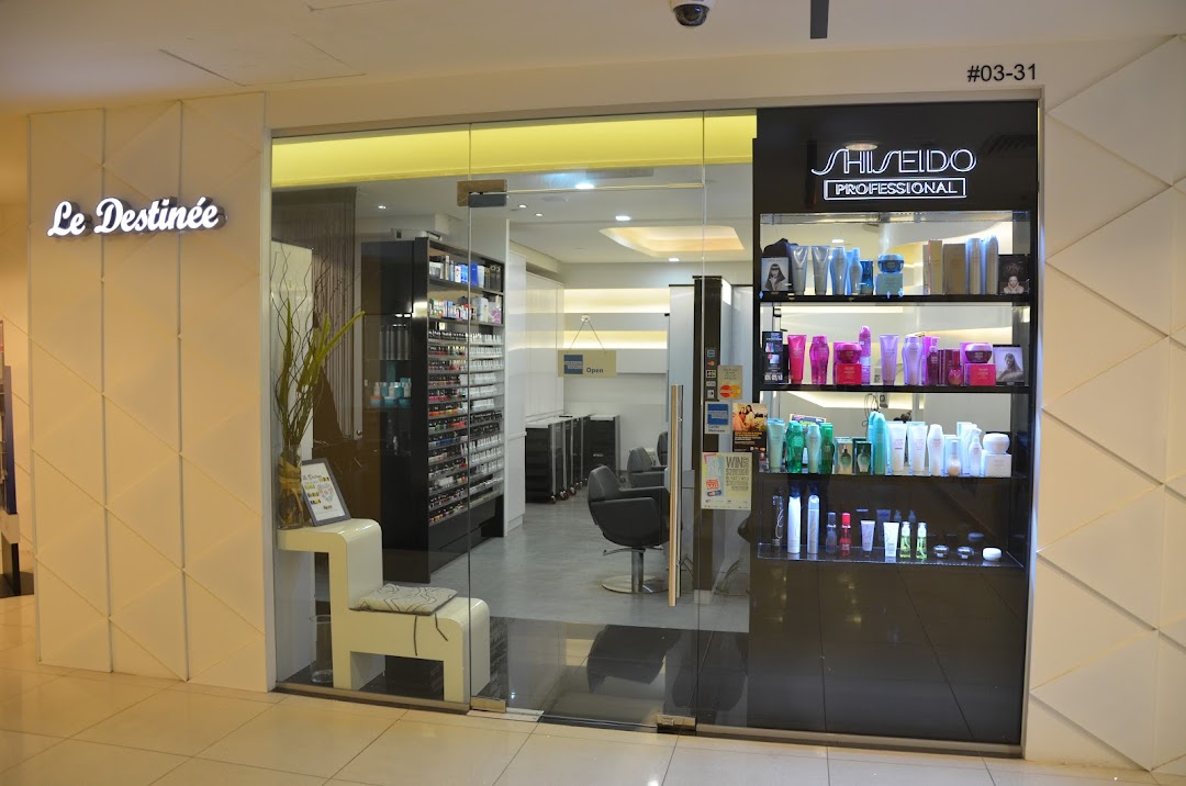 The shop front of Le Destinee, a beauty salon, featuring a glass entrance and product display.