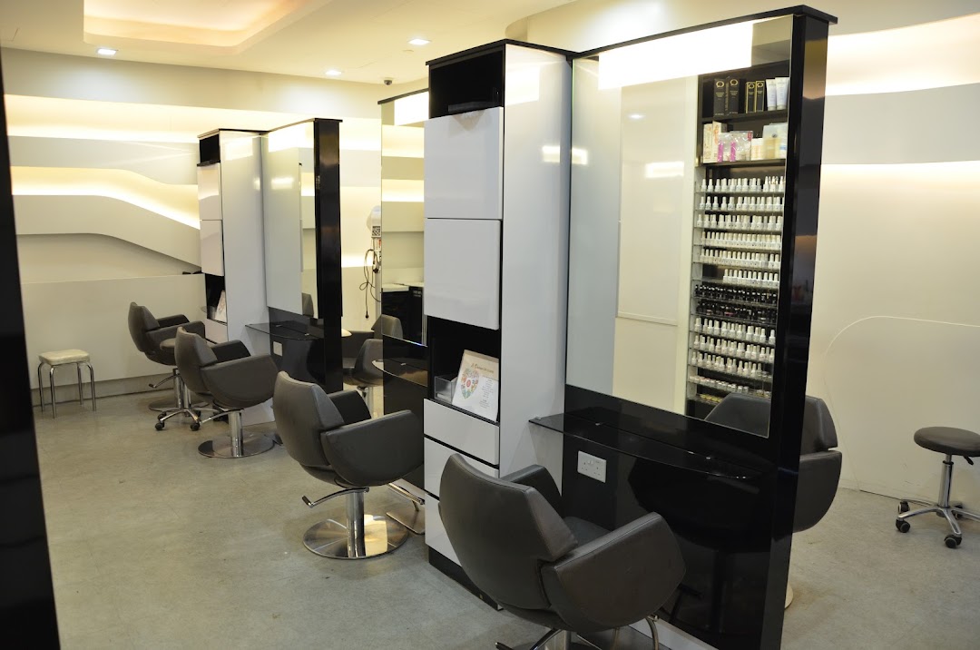 Interior view of a modern salon with styling chairs, mirrors, and product displays.
