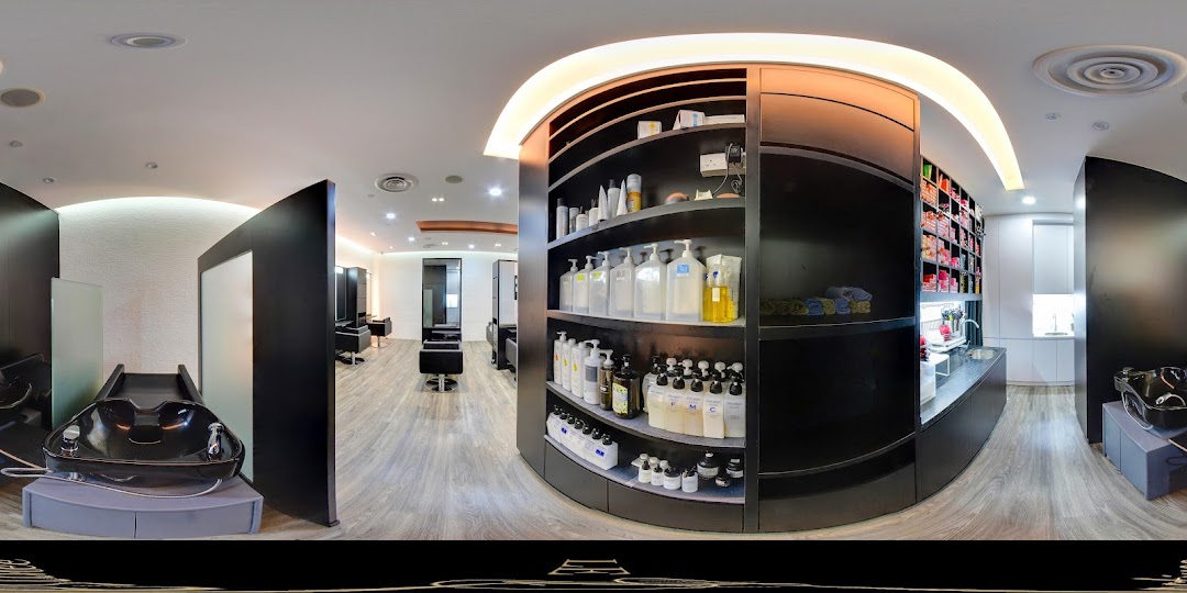 A panoramic view of a modern hair salon interior with styling stations, wash basins, and product displays.
