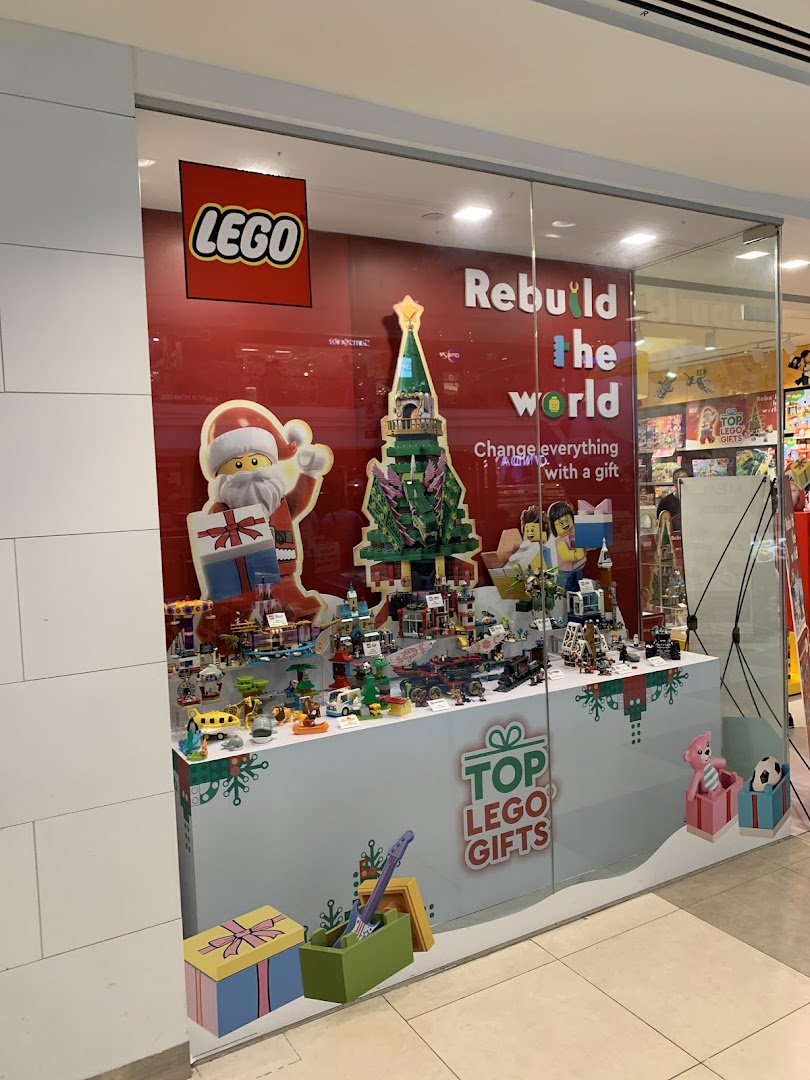 A festive LEGO Certified Store window display featuring Christmas decorations and various LEGO sets.
