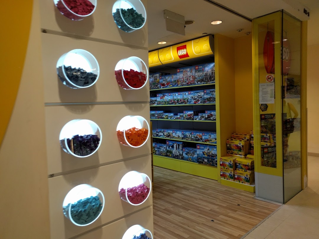 An interior view of a LEGO Certified Store, showcasing product displays and a colorful 'Pick a Brick' wall.