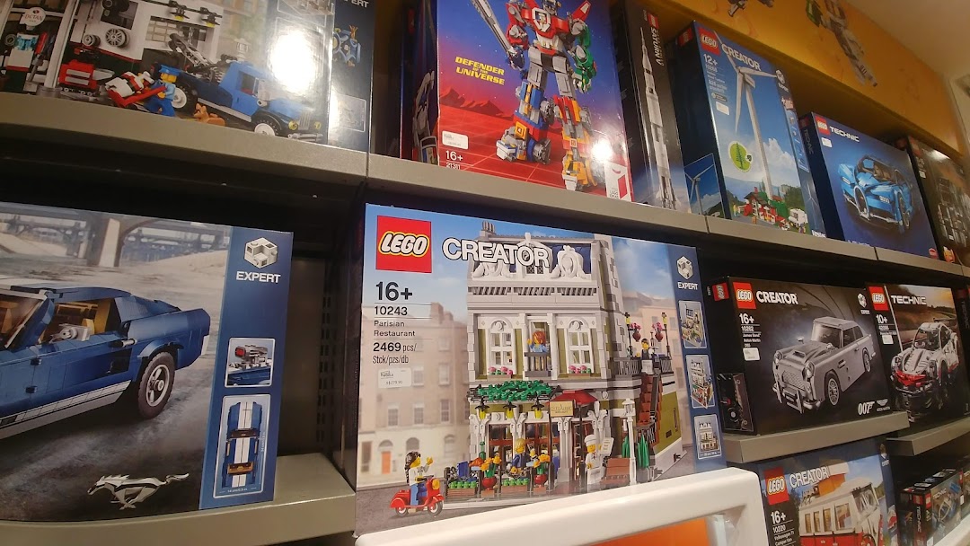 Shelves filled with diverse LEGO sets, including Creator, Technic, and Expert series, in a retail store.