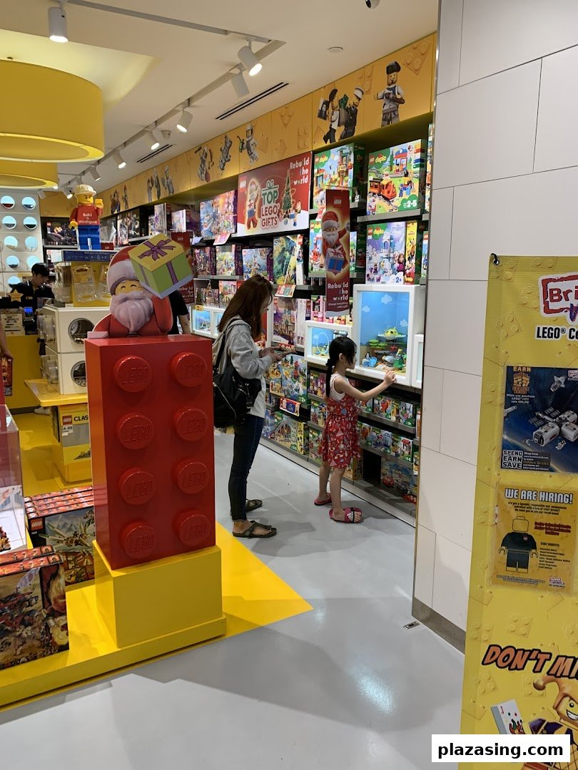 Customers browse colorful LEGO sets and displays inside the brightly lit store.