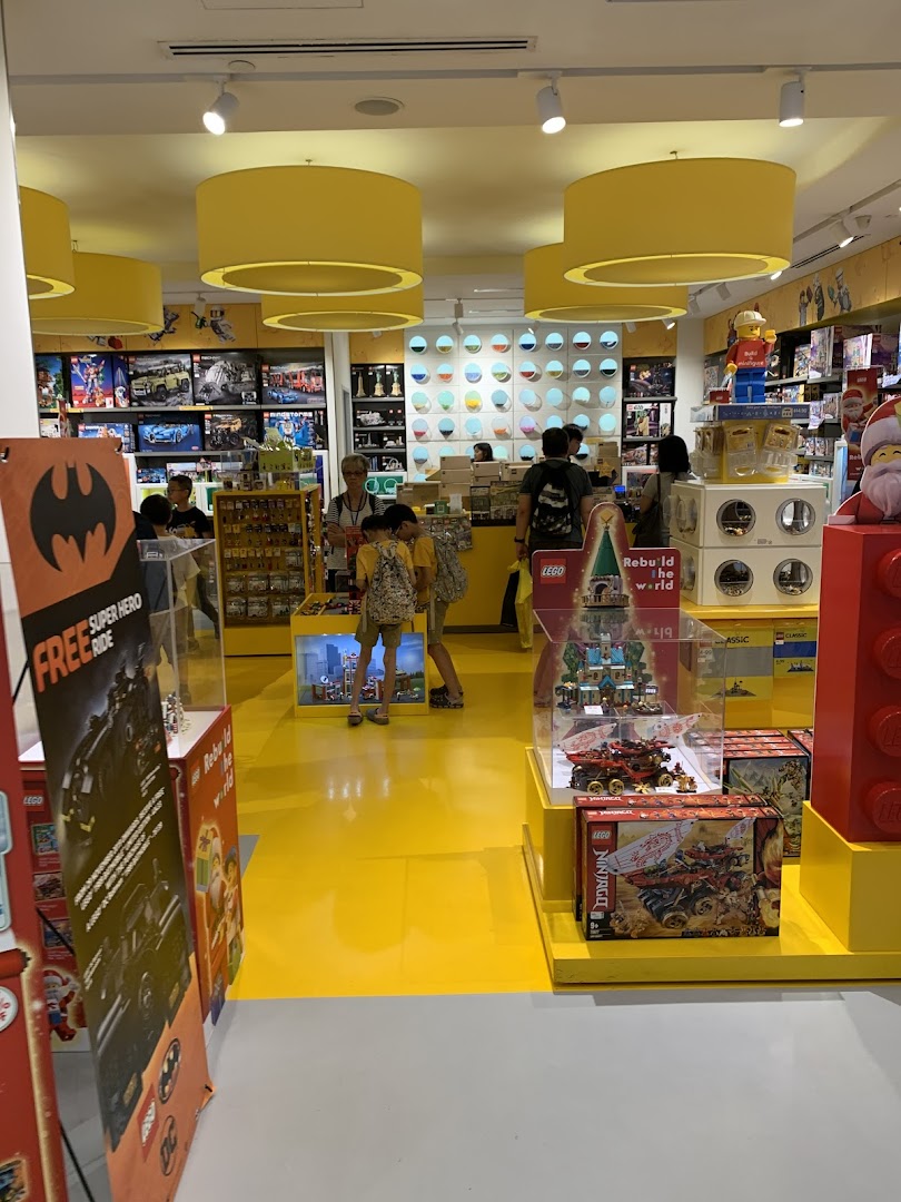 Vibrant interior of a LEGO Certified Store, showcasing various sets, displays, and shoppers.