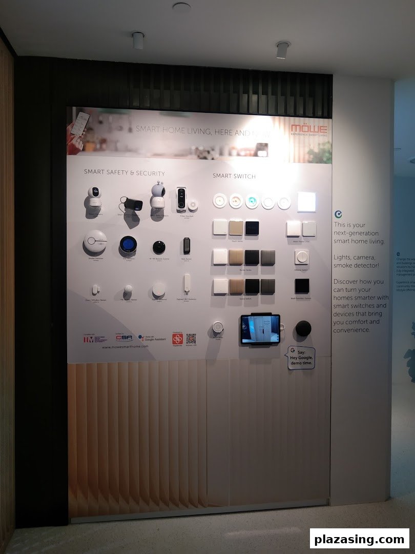 A wall display showcasing MOWE smart home devices, including security systems and smart switches.
