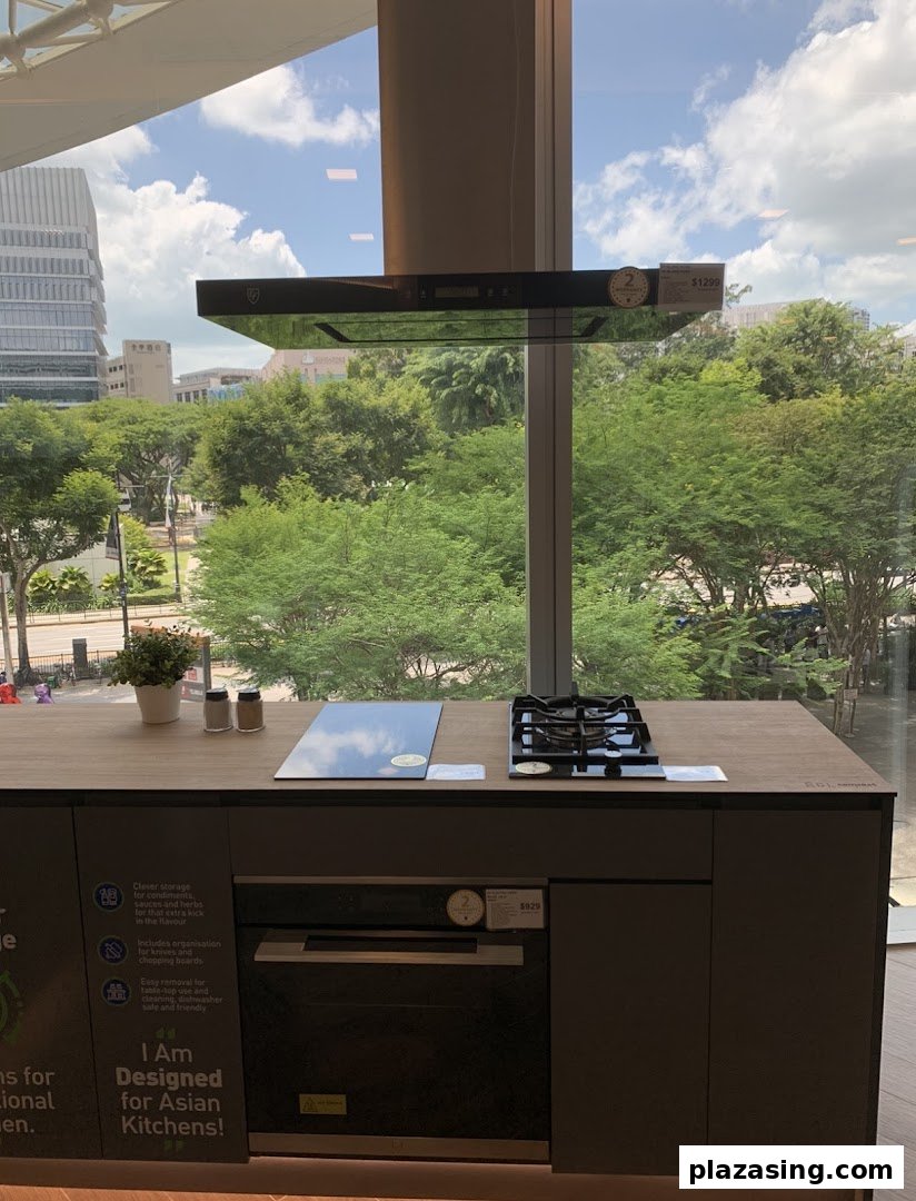 A modern kitchen display featuring an oven, hob, and hood with a city view.