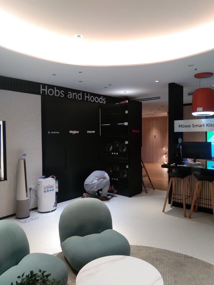 Interior view of Life by City Energy showroom featuring kitchen appliances and a person working on an installation.