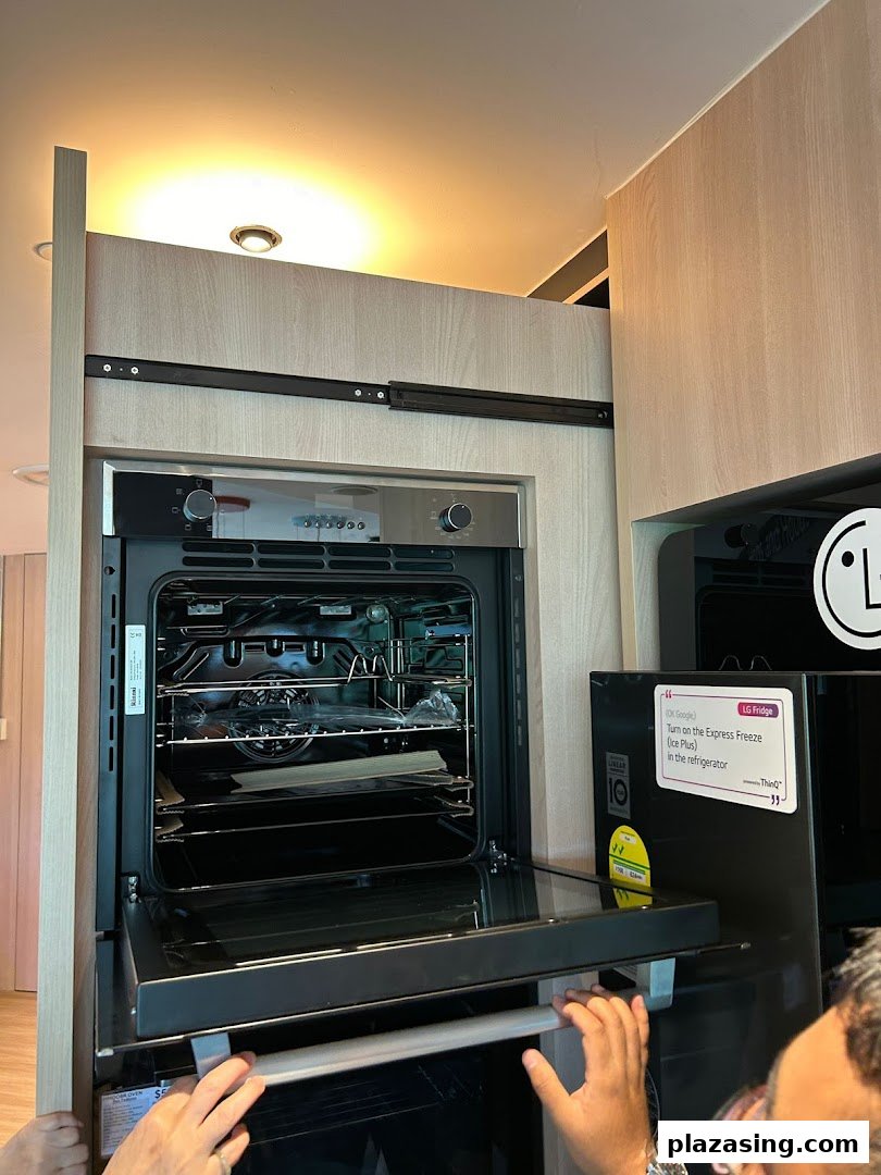 A modern kitchen display featuring an open oven and an LG smart refrigerator.