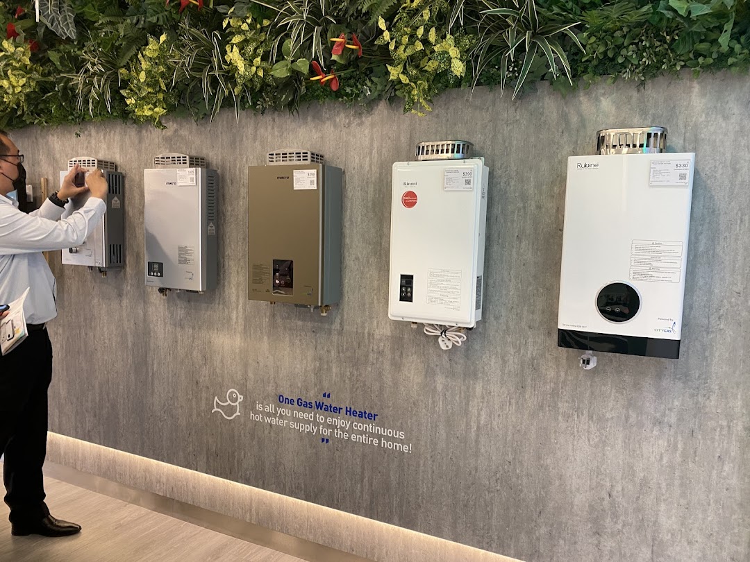 A display of various gas water heaters on a wall, with a person taking a photo.