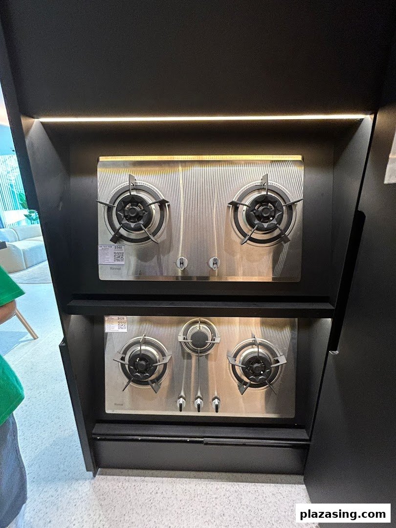 Two modern stainless steel gas hobs displayed in a retail setting.